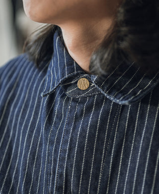 Indigo pinstripe work coat collar with brass button and white vertical stripes