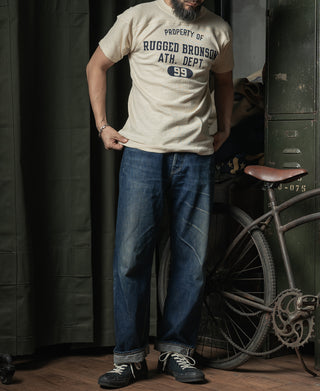 Cream football T-shirt with navy front graphic, worn with blue jeans