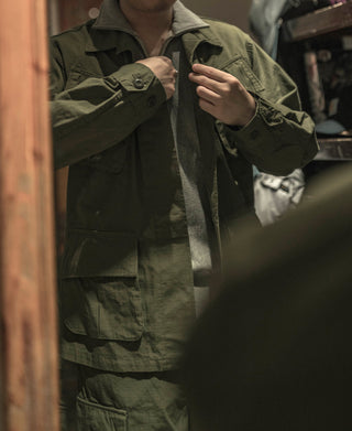 Olive tropical fatigue jacket worn, showing chest and sleeve button closures