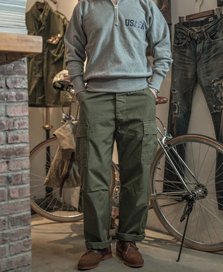 Olive fatigue pants with cargo pockets, worn with boots, full view