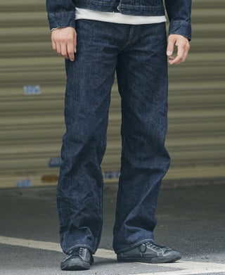 Indigo denim jeans on model, relaxed fit with cuffed hems and contrast stitching