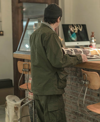 Olive field jacket with multiple cargo pockets and button closure, side view