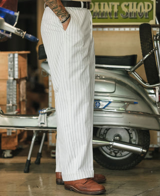 White striped trousers with belt loops and tapered cuff, full-body view