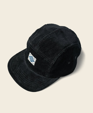 Black corduroy 5-panel cap with triangular logo patch on the front