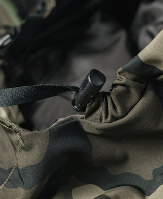 Woodland camo parka interior close-up of black buckle and strap.