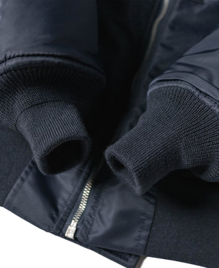 Navy ribbed cuffs with zipper opening at hem and textured knit edge
