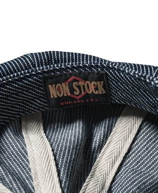 Striped denim newsboy cap interior label: NON STOCK DURABILITY on dark-blue lining.