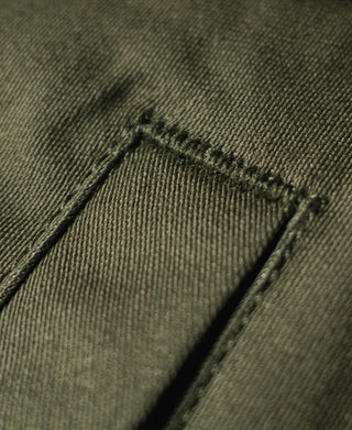Olive jacket hem panel stitching detail with folded edge