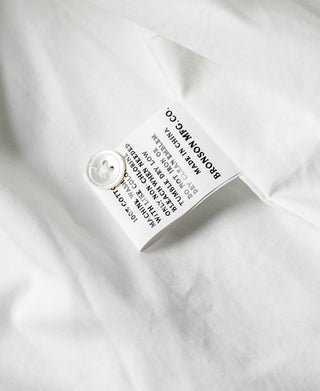 Ivory white shirt care label on fabric with round button