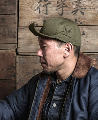 Olive WWII flight cap with curved brim and front embroidered badge