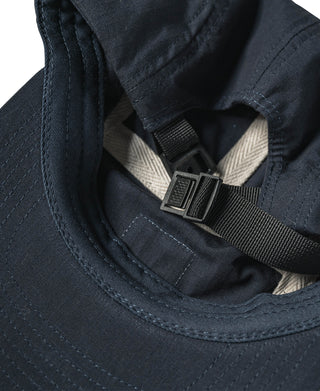 Navy cap close-up of adjustable chin strap buckle and stitched brim edge