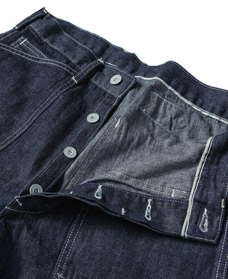 Indigo denim dungaree pants detail: button closure and interior pocket lining