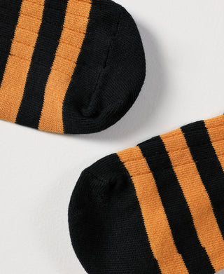 Pair of striped black and orange socks, ribbed toe and knit close-up