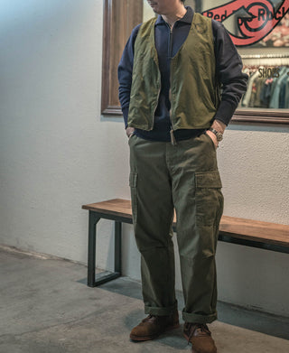 Navy half-zip sweatshirt with front zipper, layered under a vest