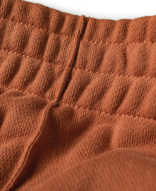 Orange ribbed waistband and straight-leg sweatpant fabric texture