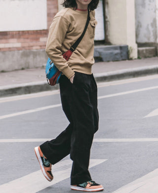 Black corduroy trousers with wide legs and front slant pockets