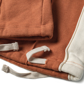 Orange sweatpants cuff with white drawstring and stitched hem