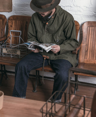 Olive hooded cotton parka with drawcord and front buttons, worn with dark pants
