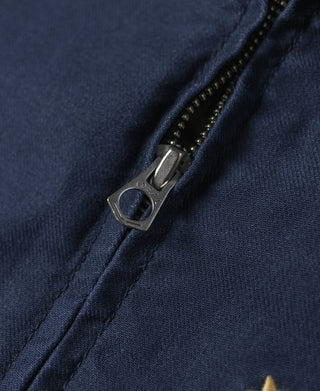 Navy tour jacket zipper with metal pull and teeth, close-up on front placket