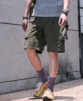 Olive utility cargo shorts with side flap pockets and relaxed knee-length fit