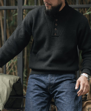 Black wool high-neck sweater with three-button placket and ribbed knit cuffs and hem