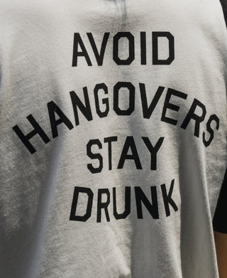 White t-shirt with black 'AVOID HANGOVERS STAY DRUNK' graphic