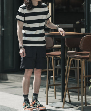 Black-and-white wide striped T-shirt with crew neck and short sleeves, standing