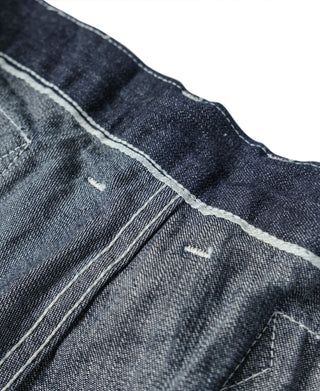 Indigo denim fatigue dungarees, close view of pocket stitching and seams