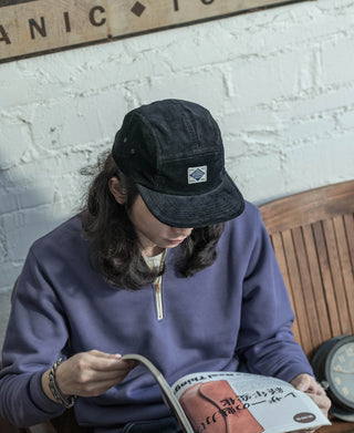 Black corduroy 5-panel cap with front triangular logo patch