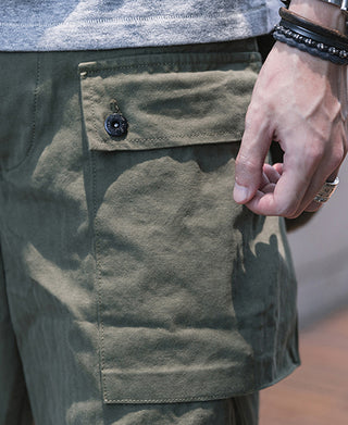 Olive cargo shorts pocket with flap and button closure, visible stitching