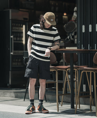 Black-and-white wide striped T-shirt with crew neck and short sleeves, side view