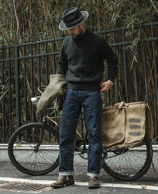 Black wool high-neck sweater with button placket and ribbed cuffs, worn outdoors
