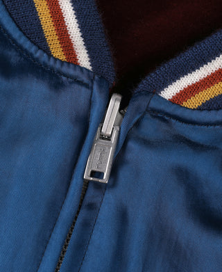 Blue reversible jacket close-up of front zipper with ribbed striped trim