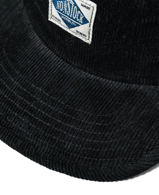 Black corduroy cap close-up of ribbed brim texture and stitched panels