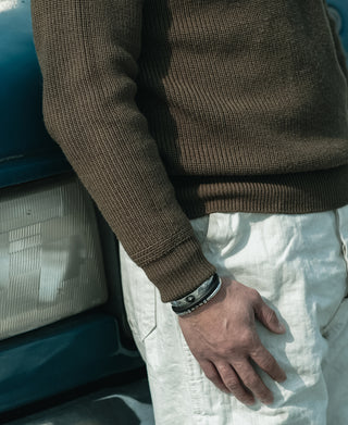 Olive wool high-neck sweater with ribbed hem and cuffs, worn with light trousers