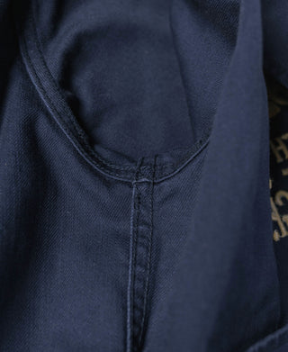 Navy tour jacket front yoke seam with central stitched placket and collar base.