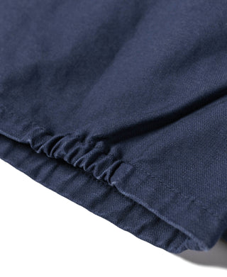 Navy tour jacket hem with elastic ruffle trim and stitched edge detail.