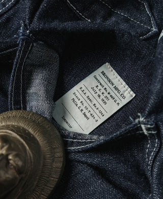 Indigo denim fatigue dungarees, interior brand label visible near waistband