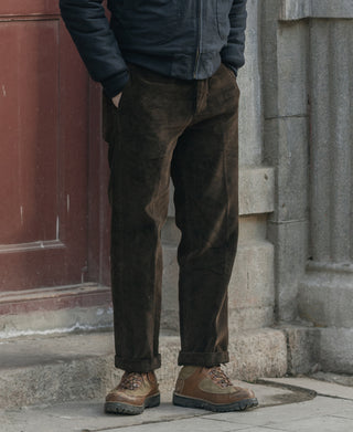 Dark brown corduroy work pants, straight legs and belt loops, side view.