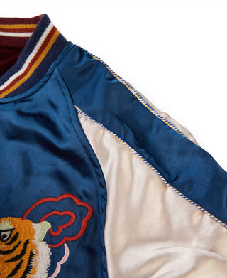 Blue reversible jacket side panel showing embroidered edge trim and tan interior lining