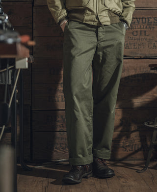 Olive M-43 field trousers close-up, side view of legs and cuffed ankle hem