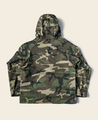 Woodland camo parka front view with large hood and full-length zipper.