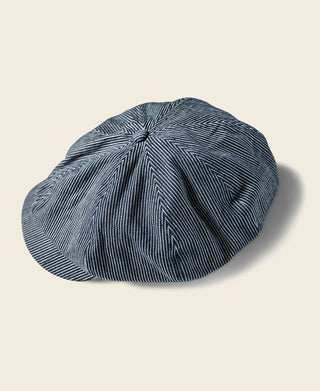 Striped denim newsboy cap, dark blue and white striped paneling with soft gathered top.