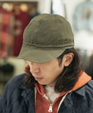 Olive reversible nylon cap with curved brim and stitched panels