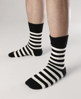 Black and white striped crew cotton socks on feet, ribbed cuff and toe detail