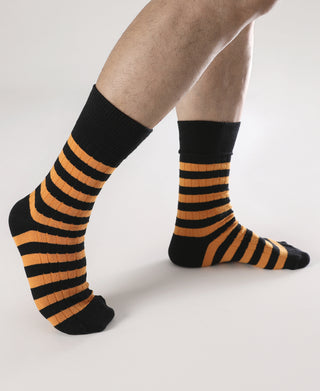 Pair of black crew socks with orange-and-black horizontal stripes.