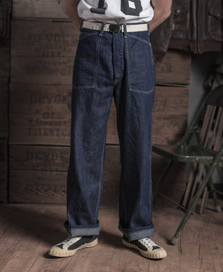 Indigo denim dungaree pants on model, straight legs with patch pockets