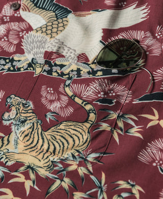 Wine red shirt fabric close-up with tiger and crane illustration and floral details