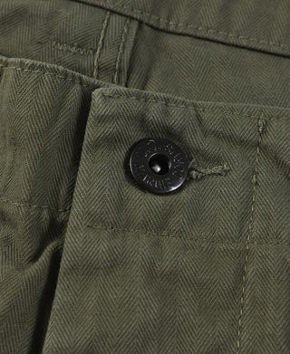 Close-up of olive utility shorts front placket with black button