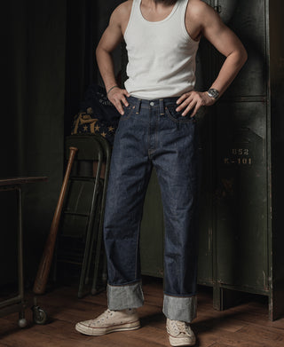 Dark indigo selvedge denim jeans with belt loops, button fly, and rolled cuff hem